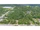 Aerial view of the real estate with lush trees, roads, and nearby buildings at 2 E Kelly Park Rd, Apopka, FL 32712