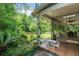 Beautiful backyard featuring a small seating area, lush greenery, and view of the screened in porch at 2 E Kelly Park Rd, Apopka, FL 32712