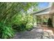 Backyard featuring a rock garden, lush bamboo, and view of the screened in porch of the home at 2 E Kelly Park Rd, Apopka, FL 32712