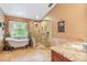 Bright bathroom features a glass shower, granite countertop, soaking tub and large window offering natural light at 2 E Kelly Park Rd, Apopka, FL 32712