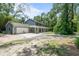 Spacious home with attached garage and a concrete driveway, surrounded by lush trees at 2 E Kelly Park Rd, Apopka, FL 32712