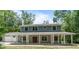Charming two-story home featuring a large, covered front porch with white pillars and a well-maintained lawn and garage at 2 E Kelly Park Rd, Apopka, FL 32712