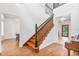 Bright foyer with beautiful wood floors, a staircase with black balusters, and a transom window door at 2 E Kelly Park Rd, Apopka, FL 32712