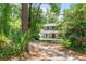 Two-story home surrounded by lush trees with an inviting front porch and landscaped yard at 2 E Kelly Park Rd, Apopka, FL 32712