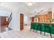 Open kitchen area with green breakfast bar, tile floors, and access to staircase at 2 E Kelly Park Rd, Apopka, FL 32712