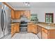 Kitchen featuring stainless steel appliances, granite countertops, tile floors, and wooden cabinets at 2 E Kelly Park Rd, Apopka, FL 32712