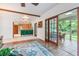 Open-concept living room with wood beams, tile floors, and glass doors to the screened-in patio at 2 E Kelly Park Rd, Apopka, FL 32712