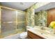 Cozy bathroom with palm tree wallpaper and glass-enclosed shower at 2080 Roseway Ave, Deltona, FL 32738