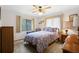 Bright bedroom with a ceiling fan, natural light, and patterned bedding at 2080 Roseway Ave, Deltona, FL 32738