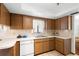 Functional kitchen with white countertops, wood cabinets, and tile floors, offering ample space for cooking at 2080 Roseway Ave, Deltona, FL 32738