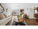 Well-lit living room with hardwood floors, a decorative mirror, and a view of the gated courtyard at 2080 Roseway Ave, Deltona, FL 32738