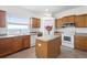 Bright kitchen with wooden cabinets, granite counters, white appliances, and a functional island at 2234 N Normandy Blvd, Deltona, FL 32725
