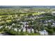 Aerial view showcasing the neighborhood with houses nestled among lush greenery and a lake nearby at 232 River Village Dr, Debary, FL 32713