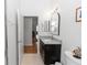 Well-lit bathroom featuring a granite countertop vanity with dark wood cabinetry, arched mirror, and tile flooring at 232 River Village Dr, Debary, FL 32713