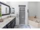 Bathroom featuring black cabinetry, granite countertops, and glass shower stall and soaking tub at 232 River Village Dr, Debary, FL 32713