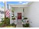 Charming entryway featuring a vibrant red door, adorned with a wreath, and a welcoming porch with flower boxes at 232 River Village Dr, Debary, FL 32713