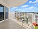 Comfortable balcony featuring outdoor chairs, a table, and picturesque views of the surrounding building and clear blue sky at 2403 S Atlantic Ave # 410, Daytona Beach, FL 32118