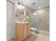 Bright bathroom featuring a glass enclosed shower and wood cabinets at 2403 S Atlantic Ave # 410, Daytona Beach, FL 32118