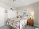 A cozy bedroom with floral bedding, a ceiling fan, and plenty of natural light offers a relaxing space at 2403 S Atlantic Ave # 410, Daytona Beach, FL 32118