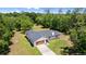 An aerial view of a home, showing its well-maintained roof, surrounding lush greenery, and private, fenced backyard at 2455 Whooping Crane Dr, De Leon Springs, FL 32130