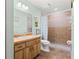 Charming bathroom featuring a tile shower, wood vanity, and mint walls at 2455 Whooping Crane Dr, De Leon Springs, FL 32130