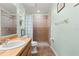 Bathroom with tile shower, wood vanity, and natural light at 2455 Whooping Crane Dr, De Leon Springs, FL 32130