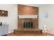 Close up of the brick fireplace with white mantle and brass screen at 2455 Whooping Crane Dr, De Leon Springs, FL 32130
