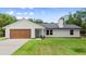 Charming single-story home featuring a new roof, an attached garage, fresh paint, and a bright green front door at 2455 Whooping Crane Dr, De Leon Springs, FL 32130