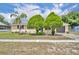 Charming single-story home featuring a well-maintained lawn and mature trees under a blue sky at 2468 Kimberly Dr, Deltona, FL 32738