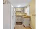 Compact kitchen featuring white appliances and wood-trimmed cabinets at 2468 Kimberly Dr, Deltona, FL 32738