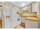 Clean kitchen featuring white appliances, light wood cabinets and bright yellow walls at 2468 Kimberly Dr, Deltona, FL 32738
