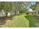Large backyard with green grass, mature trees, and white fence at 2480 S Glen Eagles Dr, Deland, FL 32724