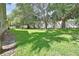 Large backyard with green grass, mature trees, and white fence at 2480 S Glen Eagles Dr, Deland, FL 32724