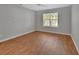 This bedroom features wood-look floors and natural light from a large window at 2480 S Glen Eagles Dr, Deland, FL 32724