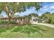 Beautifully landscaped front yard with mature trees and a brick home at 2480 S Glen Eagles Dr, Deland, FL 32724