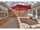 Screened outdoor patio with painted cement flooring, red umbrella, and brick accents at 2480 S Glen Eagles Dr, Deland, FL 32724