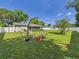Spacious backyard with lush lawn, white fence, and fire pit seating area at 2526 Victory Palm Dr, Edgewater, FL 32141