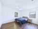 Simple bedroom with wood-look flooring, a ceiling fan, and natural light from two windows at 2526 Victory Palm Dr, Edgewater, FL 32141