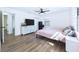 Bedroom with wood-look floors, ceiling fan, and dresser underneath the television at 2526 Victory Palm Dr, Edgewater, FL 32141