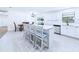 Modern kitchen with an island featuring seating, white cabinets, and tile flooring at 2526 Victory Palm Dr, Edgewater, FL 32141