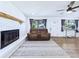 Cozy living room with a fireplace, plush seating, and ample natural light from the windows at 2526 Victory Palm Dr, Edgewater, FL 32141