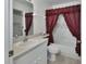 Bathroom featuring a white vanity, toilet, and a red shower curtain at 25305 Mardon Cir, Paisley, FL 32767