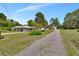 Charming single-story home with covered parking, landscaped yard and a long gravel driveway at 25305 Mardon Cir, Paisley, FL 32767