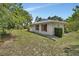 Exterior of home with red shutters, green grass and neutral color scheme, surrounded by trees at 25305 Mardon Cir, Paisley, FL 32767