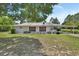 Charming single-story home featuring a well-maintained front yard and a convenient covered parking area at 25305 Mardon Cir, Paisley, FL 32767