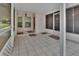 Enclosed and screened in porch with white tile, white columns, and a neutral palette at 25305 Mardon Cir, Paisley, FL 32767