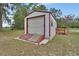 Shed with white exterior and red trim, offering outdoor storage at 25305 Mardon Cir, Paisley, FL 32767