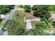An aerial view of a charming single-story home with a private driveway and lush green surroundings at 28045 Poinsettia Ave, Paisley, FL 32767