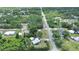 An aerial view of a charming home surrounded by mature trees with a long paved driveway and a nearby street at 28045 Poinsettia Ave, Paisley, FL 32767