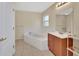 Bright bathroom features a large tub, vanity with mirror, and tiled floors at 28045 Poinsettia Ave, Paisley, FL 32767